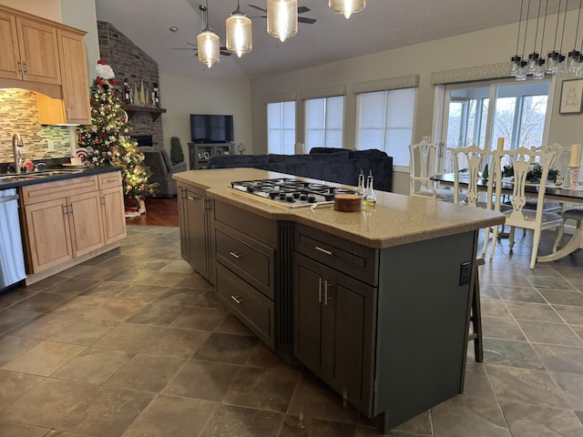 kitchen featuring sink, stainless steel appliances, decorative light fixtures, lofted ceiling, and a kitchen island