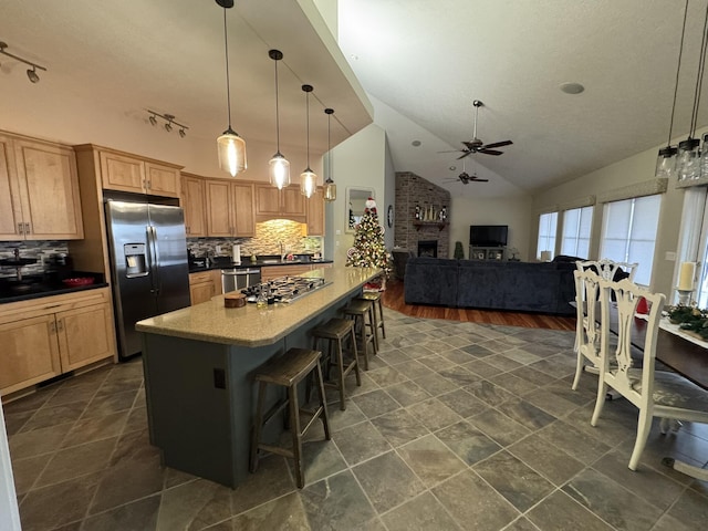 kitchen with dark hardwood / wood-style flooring, backsplash, decorative light fixtures, a breakfast bar area, and appliances with stainless steel finishes