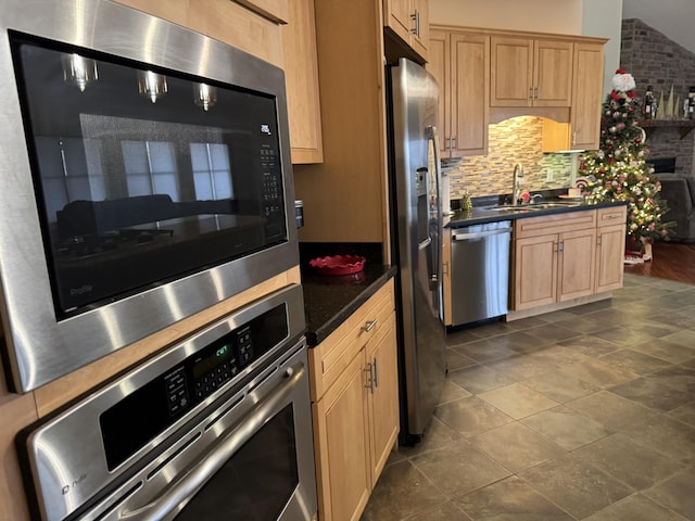 kitchen featuring light brown cabinetry, stainless steel appliances, tasteful backsplash, and sink