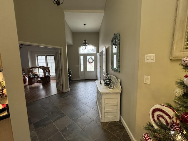 entryway featuring a towering ceiling and dark wood-type flooring