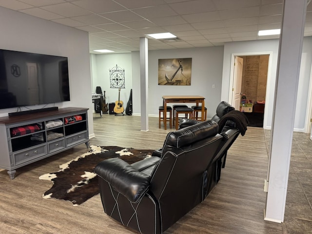 living room featuring a paneled ceiling and hardwood / wood-style flooring