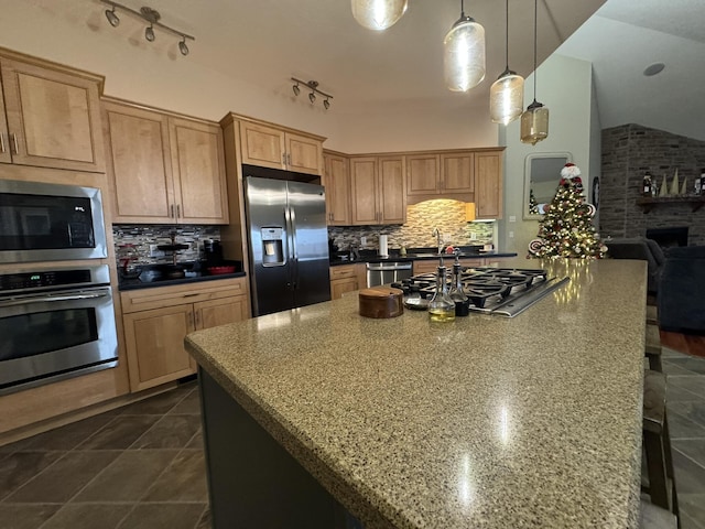 kitchen with backsplash, light stone countertops, stainless steel appliances, and lofted ceiling