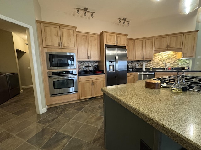 kitchen featuring backsplash, sink, stainless steel appliances, and track lighting