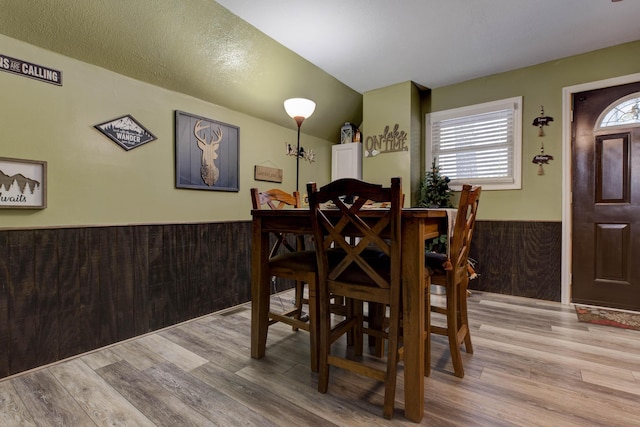 dining room featuring wooden walls and light hardwood / wood-style flooring