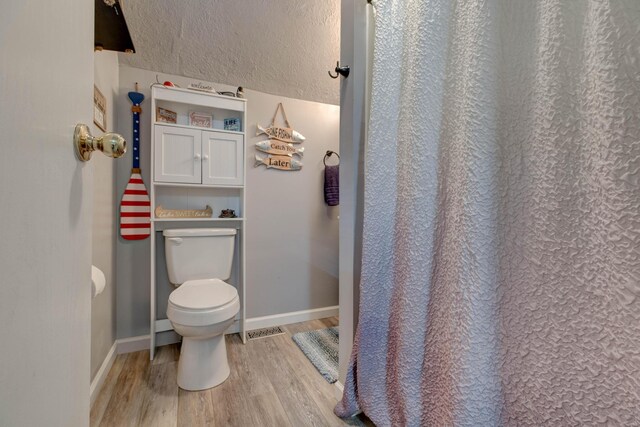 bathroom with toilet and wood-type flooring