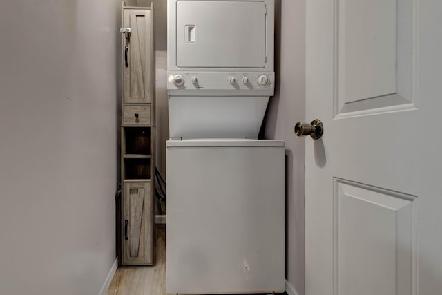 laundry room with light hardwood / wood-style flooring and stacked washer / drying machine