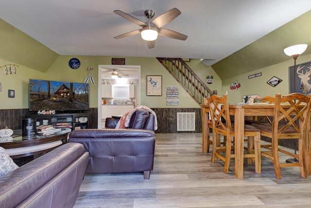 living room with light wood-type flooring, vaulted ceiling, and ceiling fan