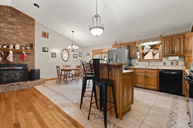 kitchen with dishwasher, a center island, stainless steel fridge with ice dispenser, lofted ceiling, and a kitchen bar