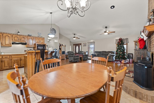 tiled dining room featuring lofted ceiling and ceiling fan with notable chandelier