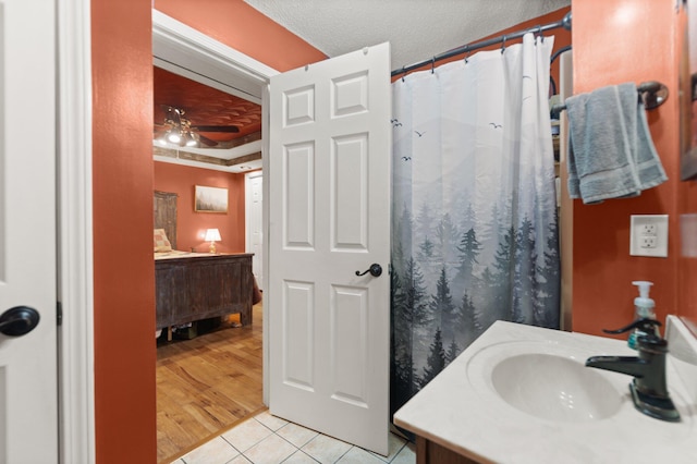 bathroom featuring wood-type flooring, vanity, a textured ceiling, and ceiling fan