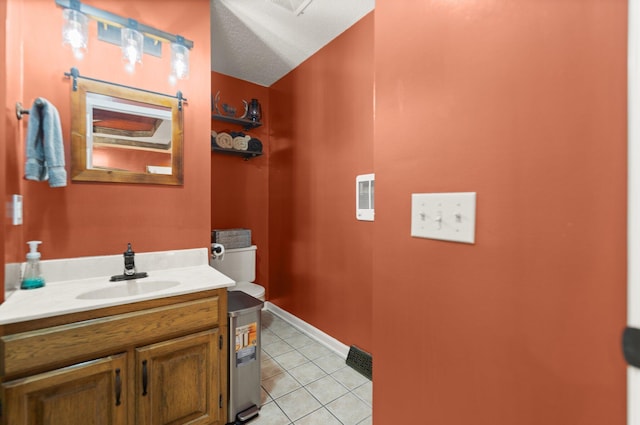 bathroom featuring tile patterned flooring, vanity, toilet, and a textured ceiling