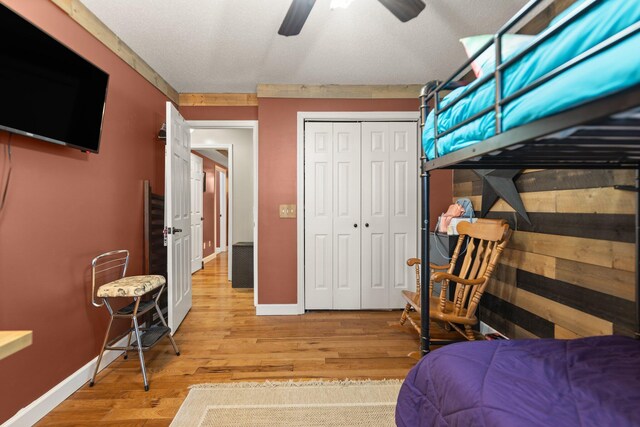 bedroom featuring ceiling fan, light wood-type flooring, and a closet