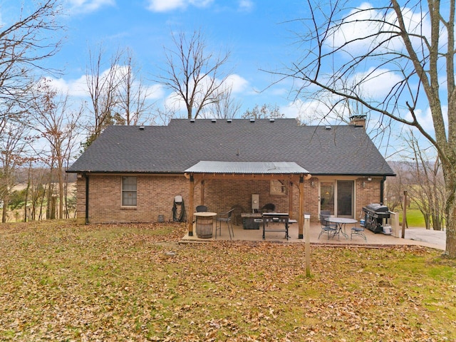 rear view of house with a lawn and a patio area