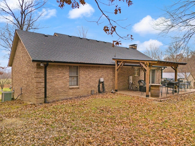 back of property with central air condition unit, a yard, and a patio