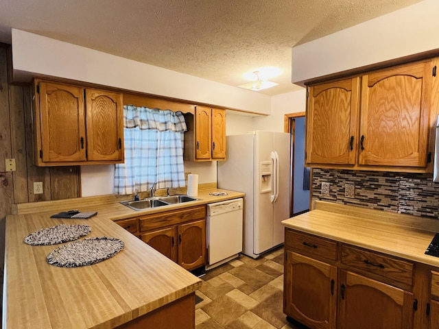 kitchen featuring a textured ceiling, white appliances, tasteful backsplash, and sink