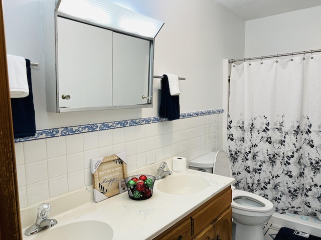 bathroom with vanity, curtained shower, toilet, and tile walls