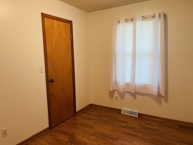 unfurnished room with dark hardwood / wood-style floors