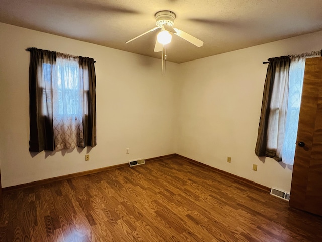 spare room featuring ceiling fan, dark hardwood / wood-style flooring, and a textured ceiling