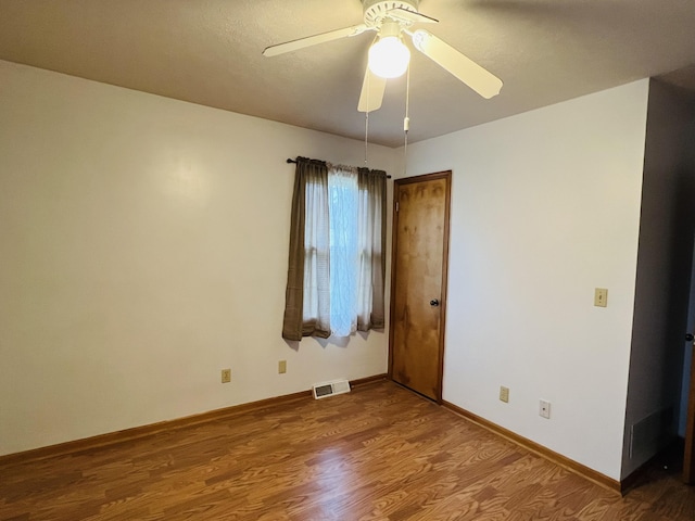 spare room with hardwood / wood-style floors and ceiling fan