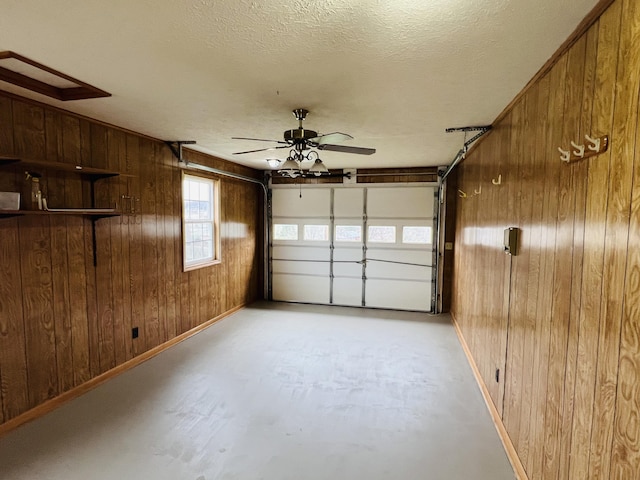 garage with ceiling fan and wooden walls