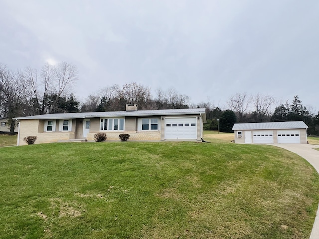 single story home with a front yard, an outbuilding, and a garage