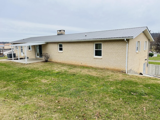 back of house featuring central air condition unit, a patio area, and a yard