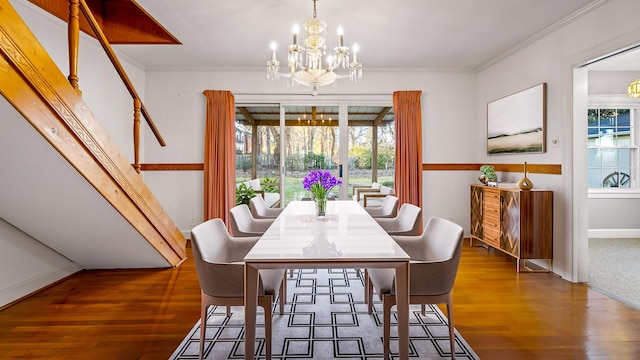 dining space with dark hardwood / wood-style flooring, crown molding, and a notable chandelier