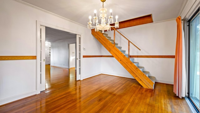 interior space featuring plenty of natural light, wood-type flooring, ornamental molding, and a chandelier