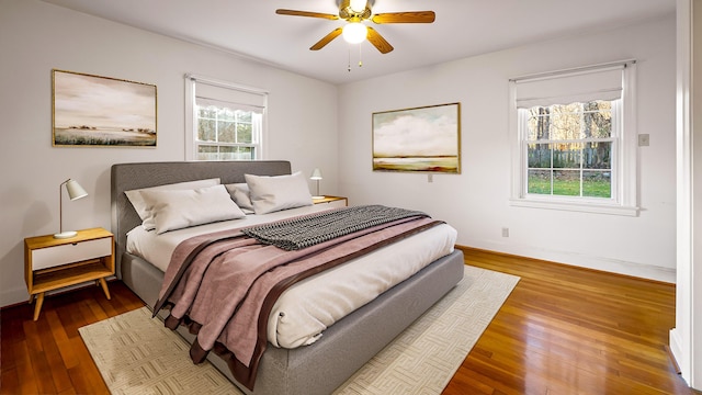 bedroom featuring multiple windows, ceiling fan, and hardwood / wood-style flooring