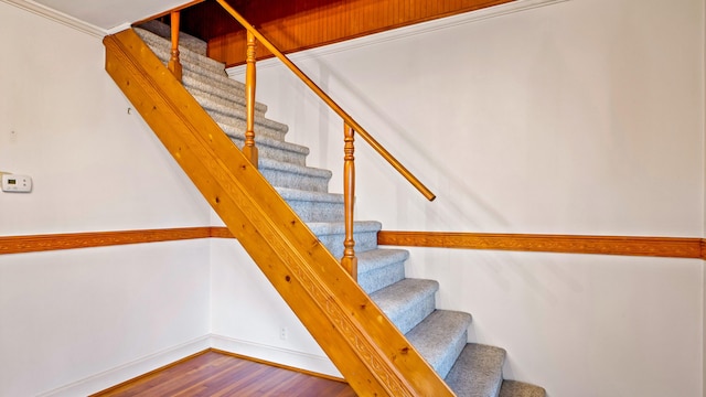 stairway with hardwood / wood-style floors and ornamental molding