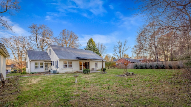 rear view of property with a yard and cooling unit