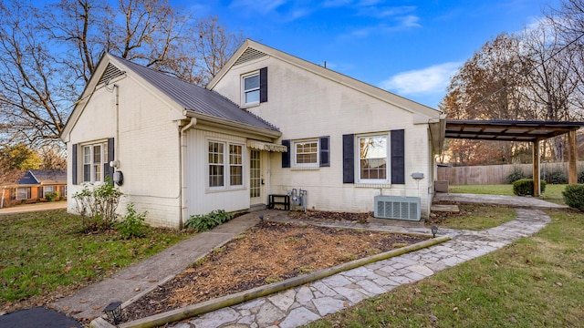 view of front of property with a front yard, central AC unit, and a carport