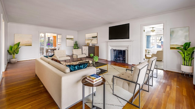 living room with ornamental molding, hardwood / wood-style flooring, ceiling fan, and a healthy amount of sunlight