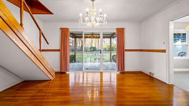 unfurnished dining area with a chandelier, hardwood / wood-style flooring, and ornamental molding