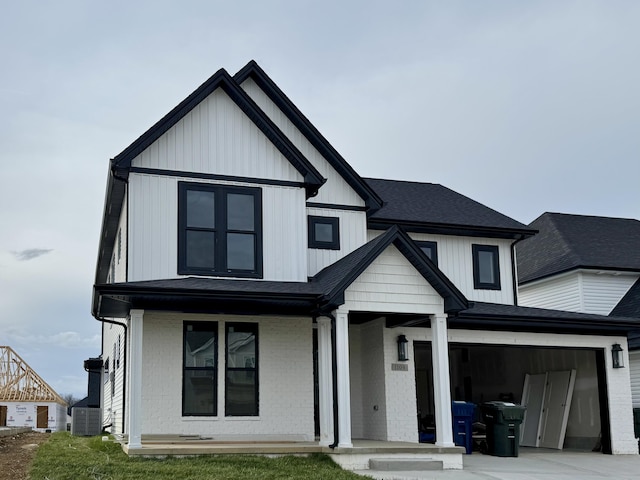 view of front facade with covered porch, a garage, and central air condition unit