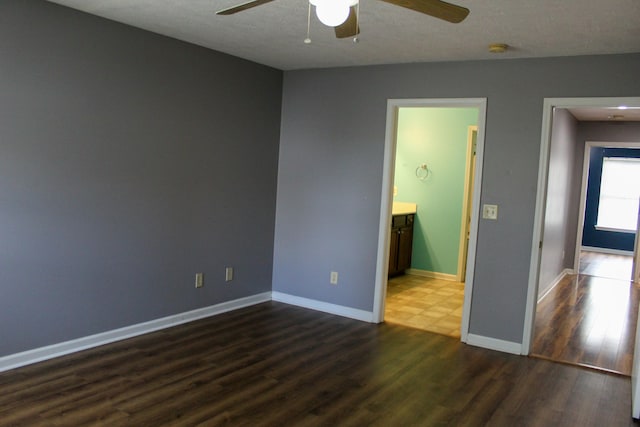 unfurnished bedroom featuring a textured ceiling, connected bathroom, ceiling fan, and dark hardwood / wood-style floors