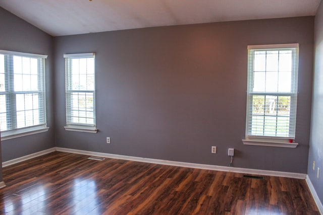 unfurnished room featuring dark hardwood / wood-style floors and vaulted ceiling