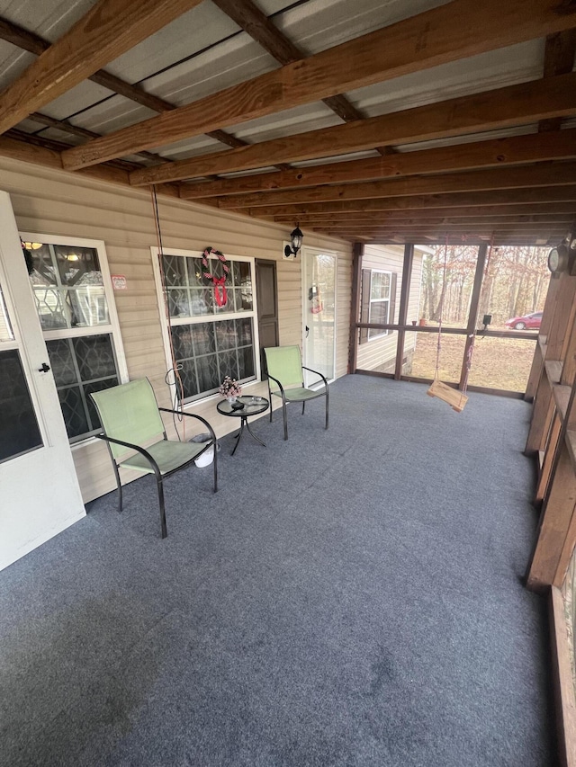 unfurnished sunroom featuring beam ceiling