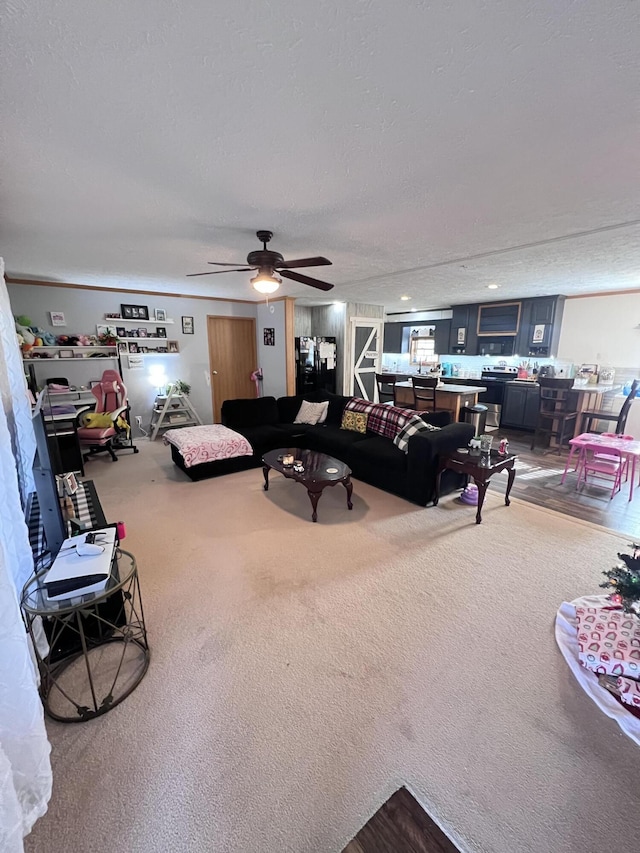 living room with carpet flooring, ceiling fan, and a textured ceiling