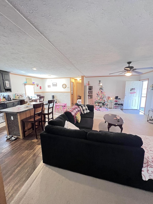 living room with a textured ceiling, ceiling fan, and dark wood-type flooring