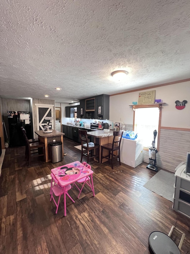 living room featuring sink, dark hardwood / wood-style flooring, and a textured ceiling