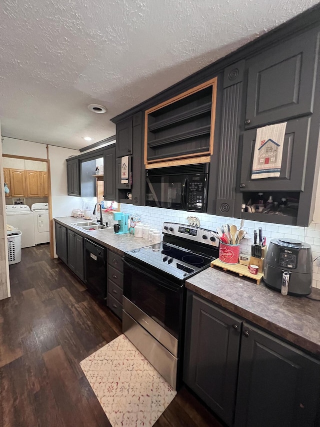 kitchen featuring backsplash, dark wood-type flooring, black appliances, sink, and washing machine and dryer