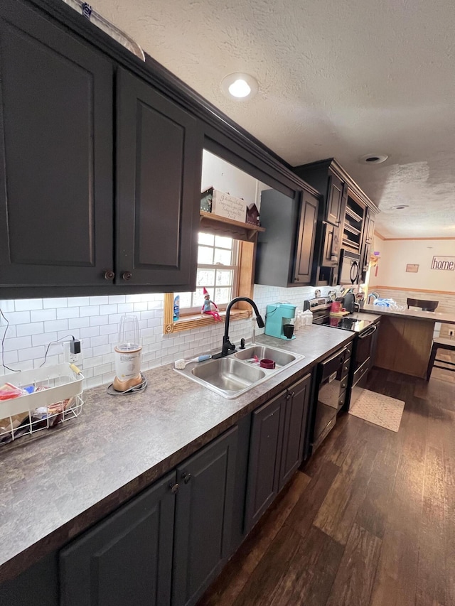 kitchen featuring sink, dark hardwood / wood-style flooring, a textured ceiling, decorative backsplash, and black appliances