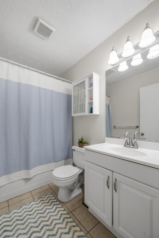 full bathroom featuring shower / bath combination with curtain, vanity, a textured ceiling, tile patterned flooring, and toilet