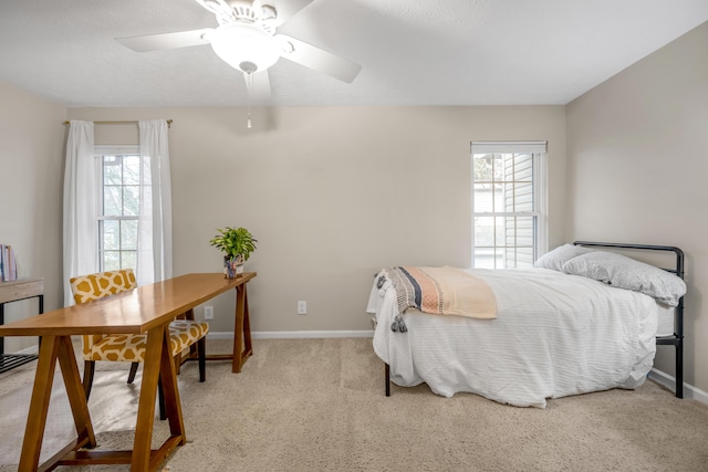 bedroom with multiple windows, ceiling fan, and light colored carpet