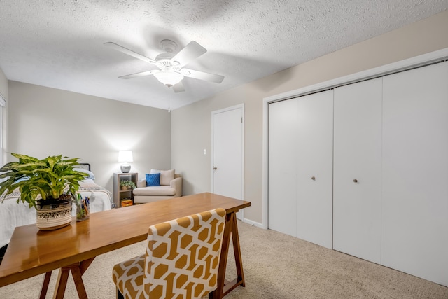 home office featuring a textured ceiling, light colored carpet, and ceiling fan