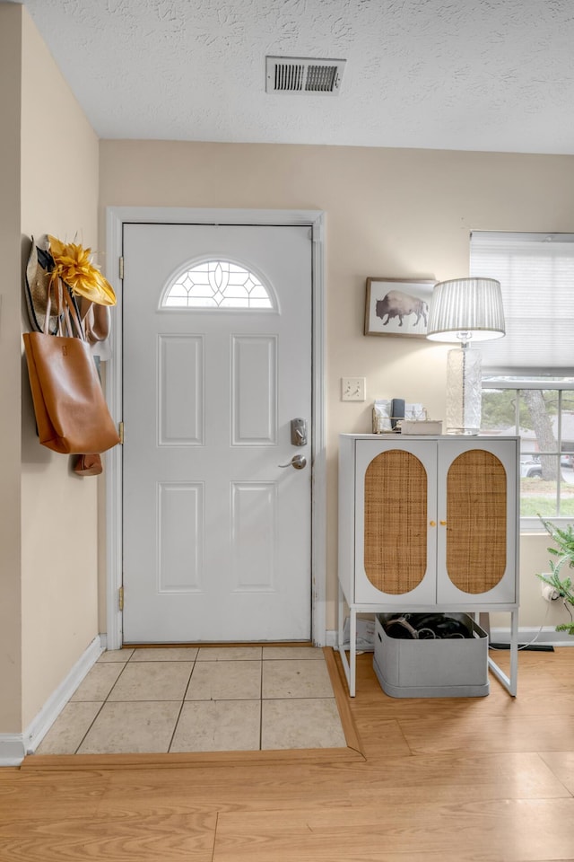 entryway with tile patterned floors and a textured ceiling