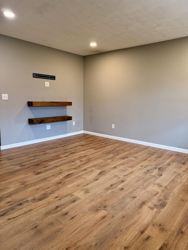 unfurnished living room featuring light hardwood / wood-style flooring and a textured ceiling