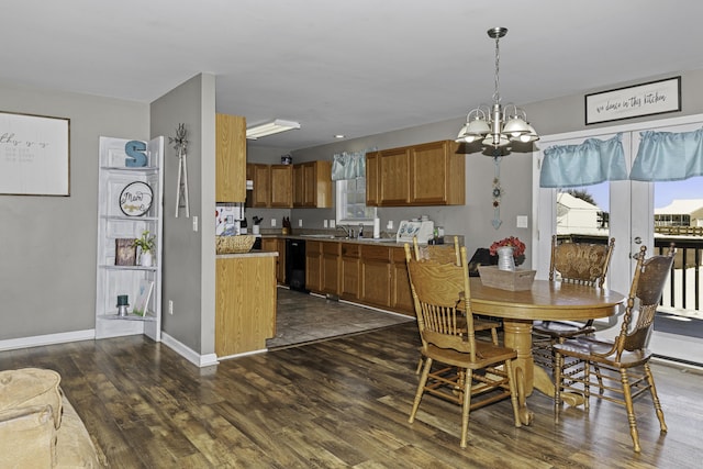 dining room with sink, dark hardwood / wood-style floors, and a notable chandelier