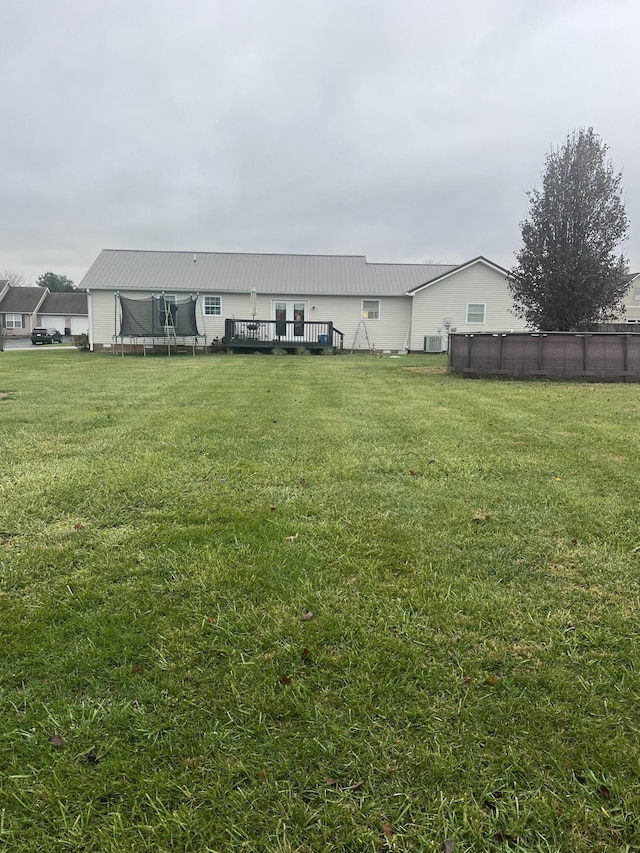 view of yard with a deck and a trampoline